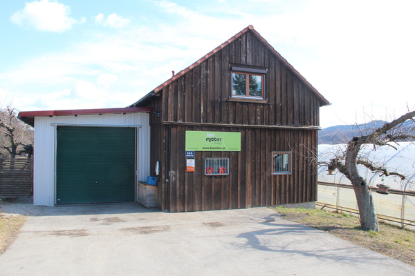 KI generiert: Holzgebäude mit Garage und Schild "bio meixner" sowie Website www.biomeixner.at.