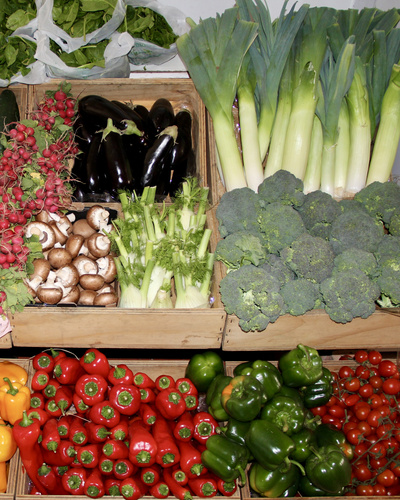 KI generiert: Verschiedene frische Gemüsearten, wie Auberginen, Lauch, Paprika und Brokkoli, in Holzkisten ausgestellt.
